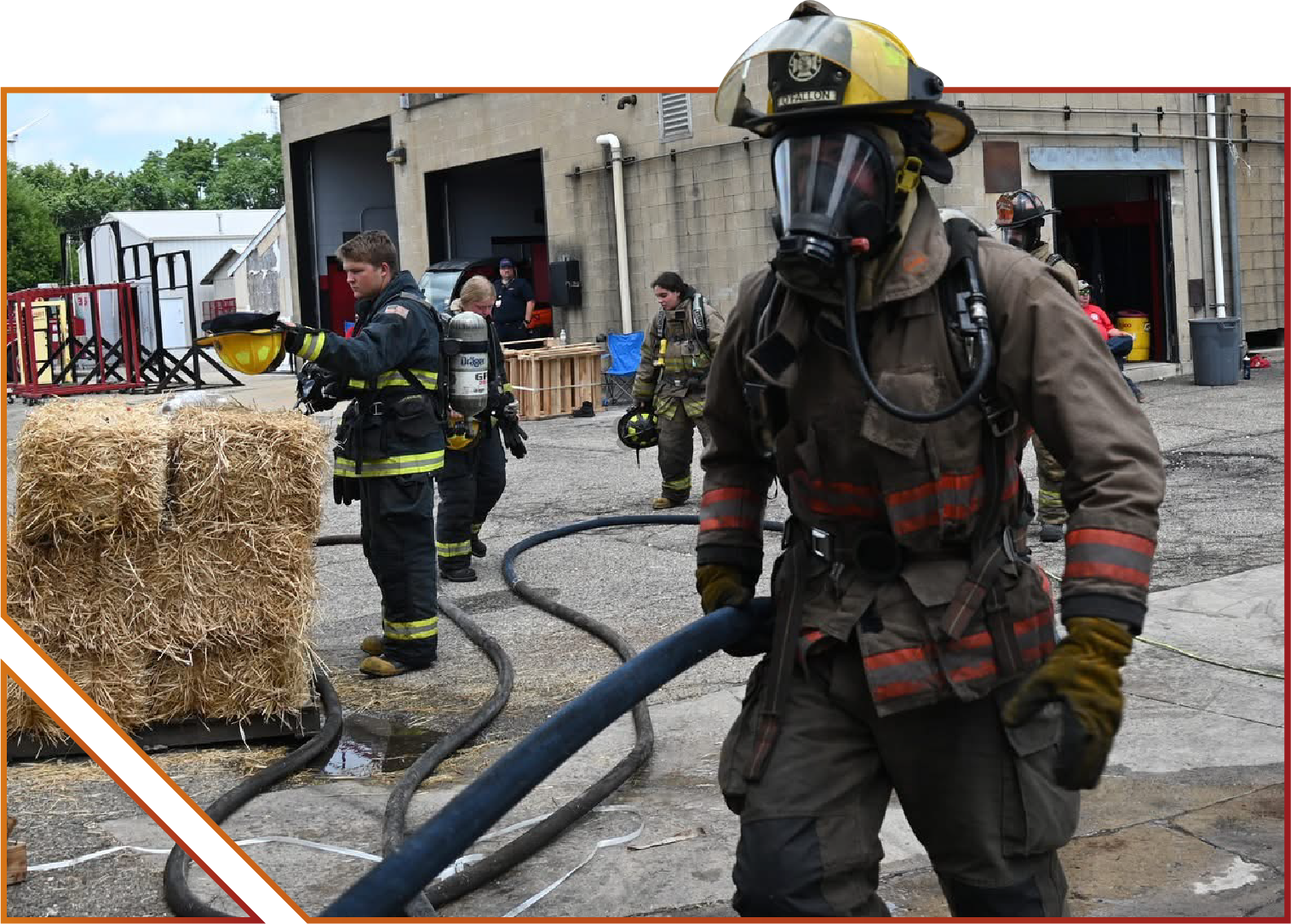 Explorer Post participant wearing firefighting suit and walking with hose